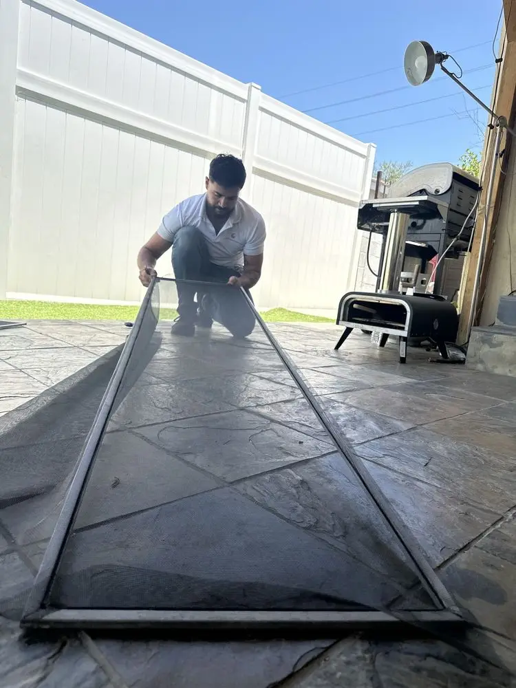 Technician rescreening a door frame on a work table